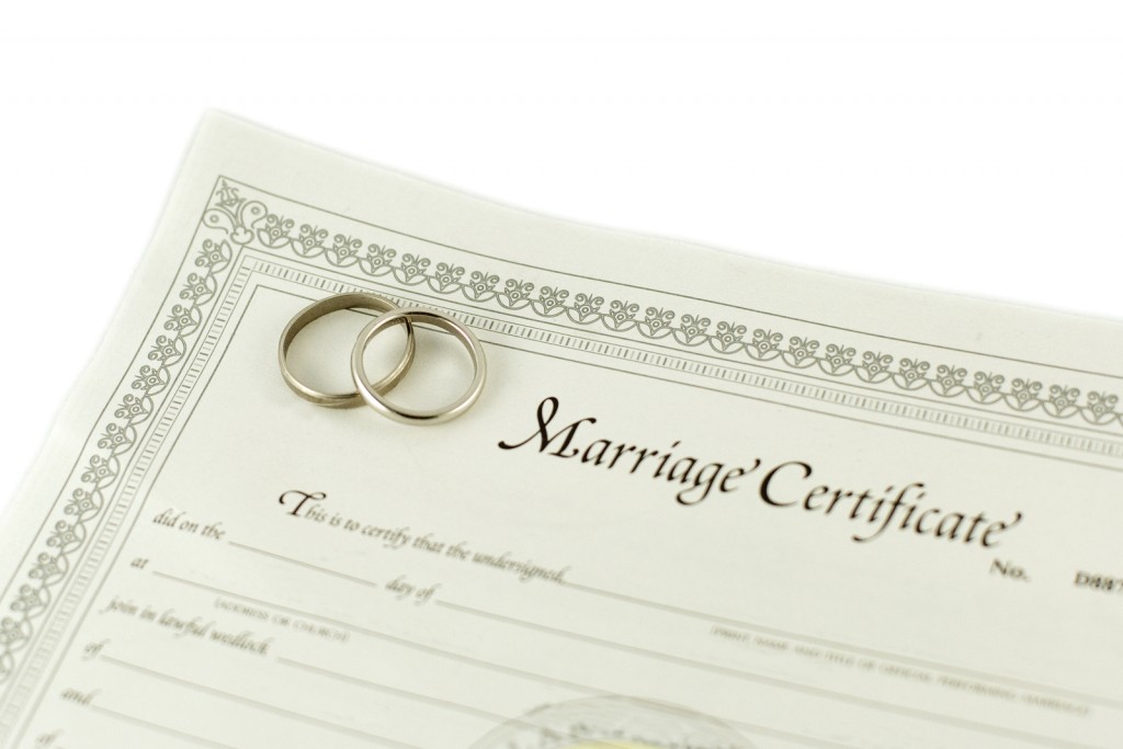 isolated blank certificate with wedding rings